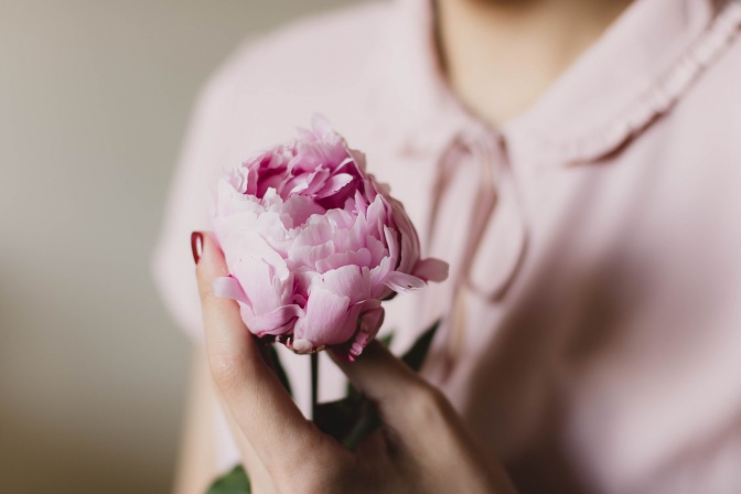 Eine Frau hält eine Blume in der Hand