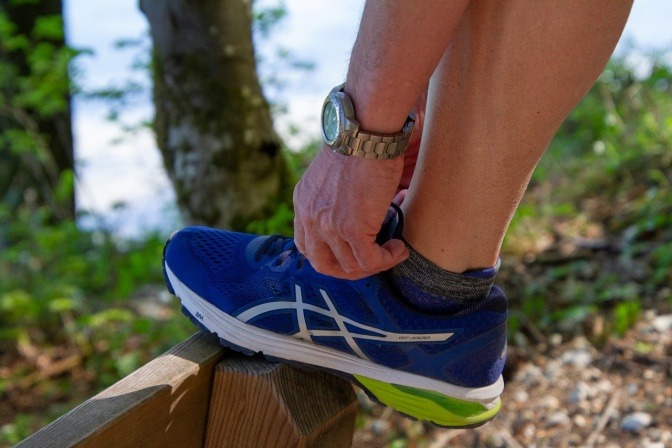 Jemand schnürt einen Laufschuh.