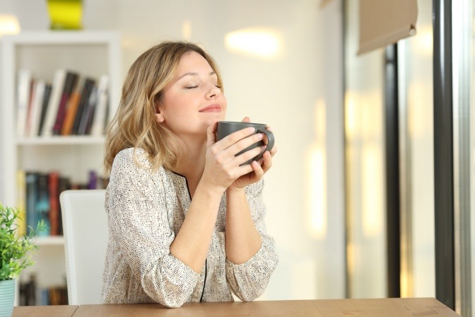 Eine Frau hält bewusst positiv eine Tasse 