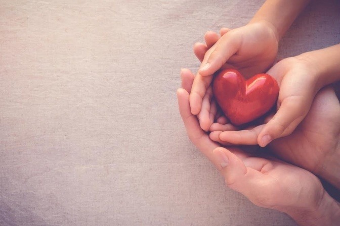 Zwei Hände halten ein Herz als Zeichen für Liebe