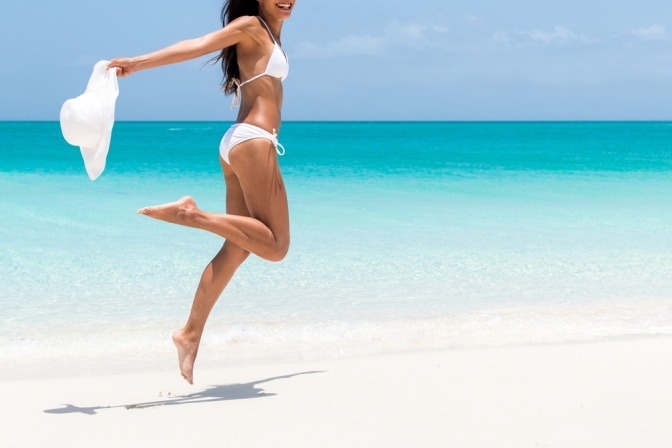 Frau am Strand im weißen Bikini