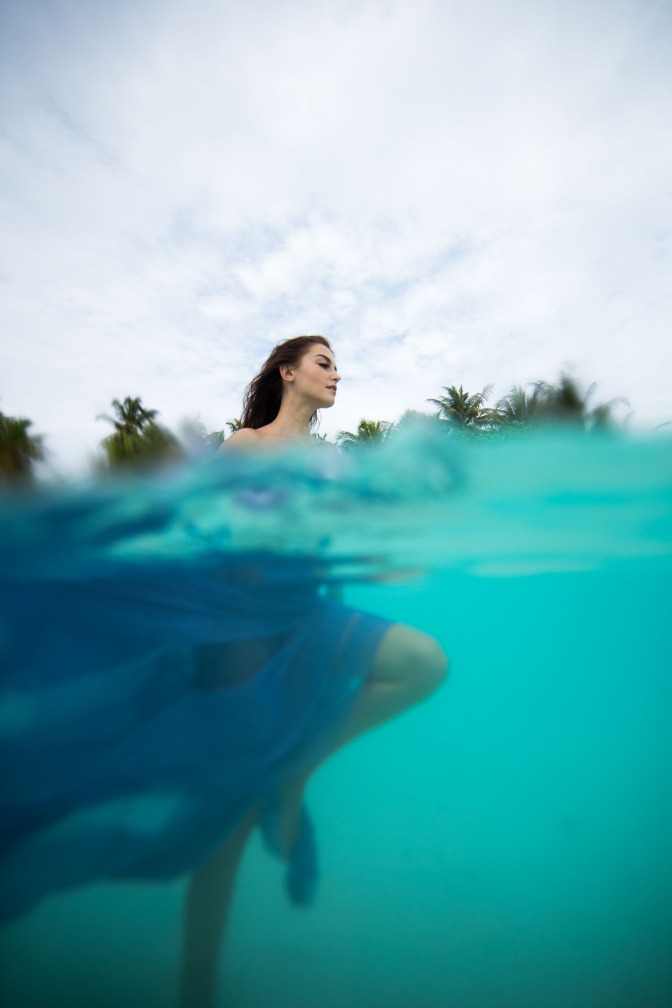 Eine Frau in blauem Kleid ist unter Wasser