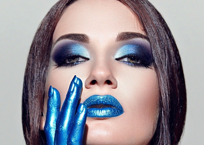 Eine Frau ist mit blauem Lippenstift und blauem Lidschatten geschminkt