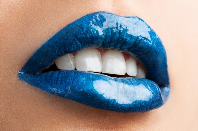 Blauer Lippenstift schmückt die Lippen einer Frau