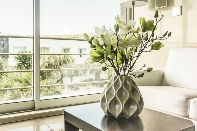 Auf einem Tisch steht eine Vase mit weißen Blumen