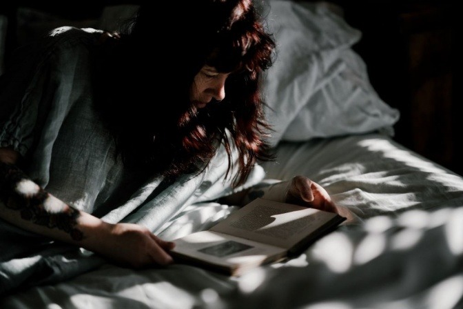 Eine Frau liest ein Buch im Bett