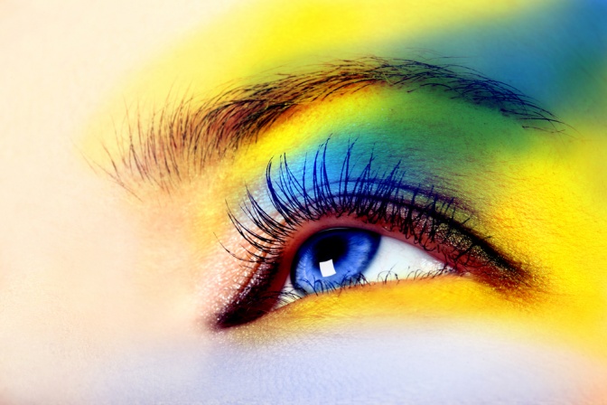 Das Auge einer Frau ist in bunten Farben geschminkt