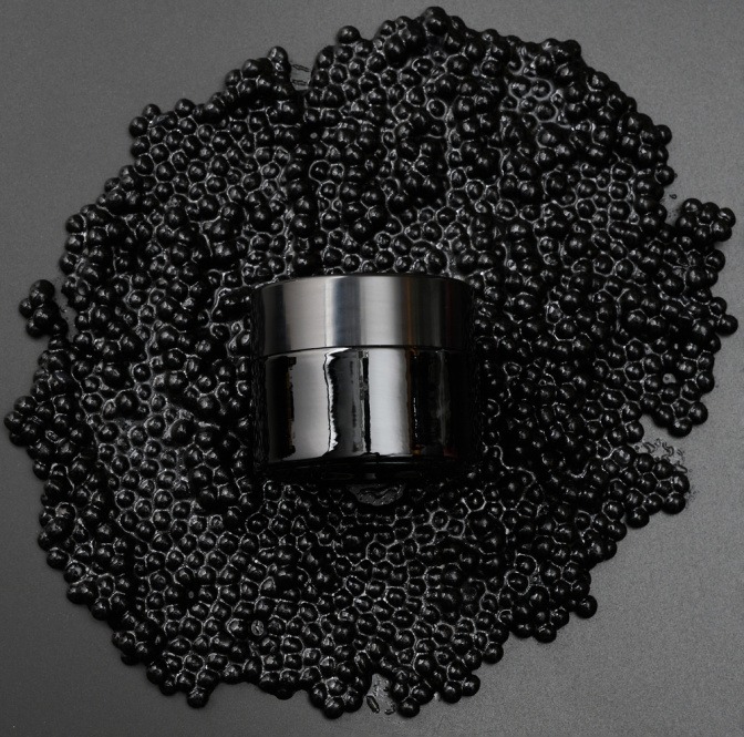 Cremetiegel auf schwarzem Kaviar