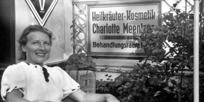 Charlotte Meentzen sitzt vor einem Schild mit dem Namen