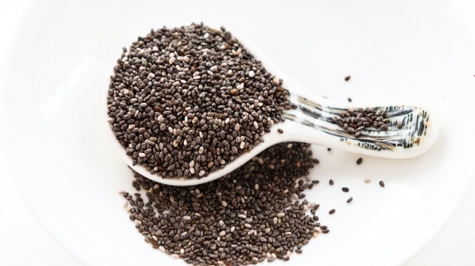 Chiasamen gelten als Superfood und liegen auf und neben einem Löffel
