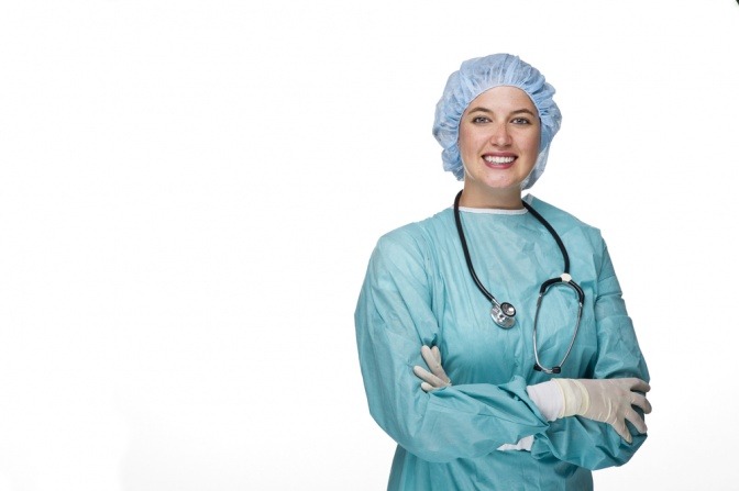 Eine Chirurgin steht für eine Brustvergrößerung im Ausland angezogen mit verschränkten Händen