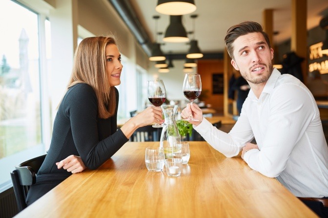 Junges Paar trinkt Wein bei einem Rendezvous im Restaurant oder Bistro.