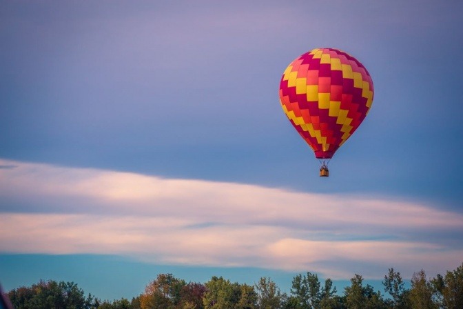 Ein Heißluftballon fliegt über Bäumen. Eine Idee für ein Date
