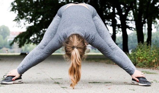 Eine Frau dehnt sich beim Joggen