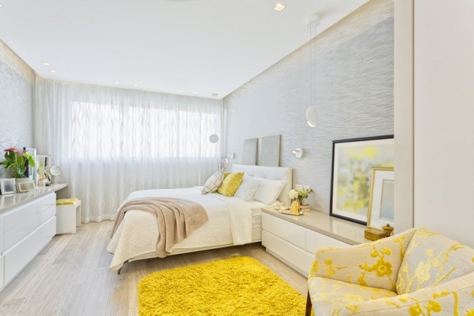 Ein Wohnzimmer wurde mit gelben Akzenten und Glasgegenständen dekoriert