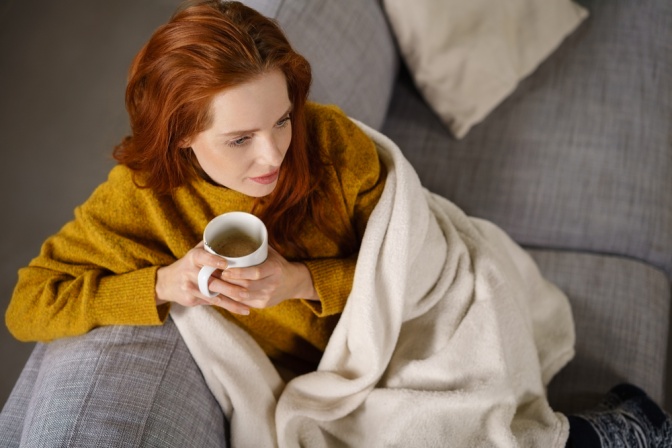 Eine Frau sitzt deprimiert auf einer Couch