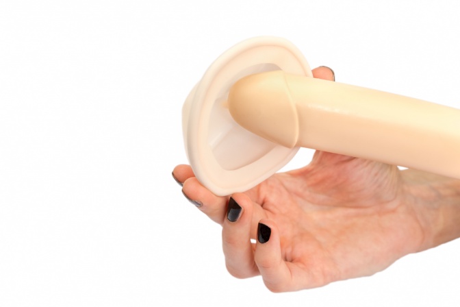 Eine Frau zeigt mit einem künstlichen Penis wie ein Diaphragma funktioniert