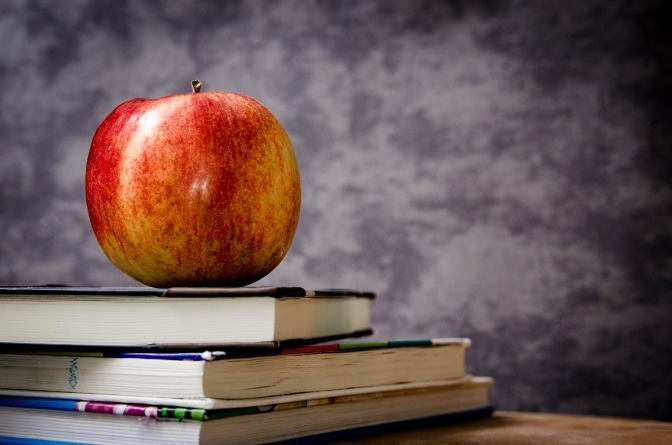 Apfel auf einem Bücherstapel.