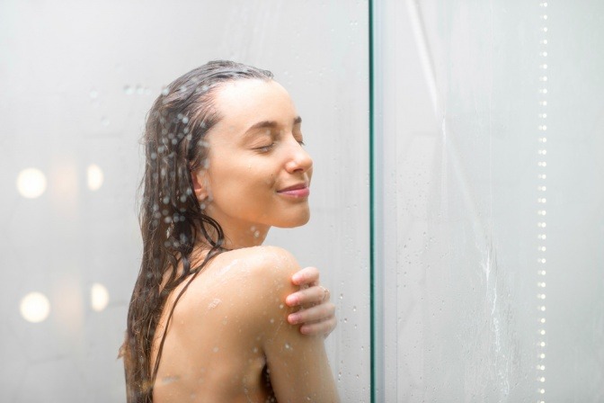 Eine Frau steht unter der Dusche