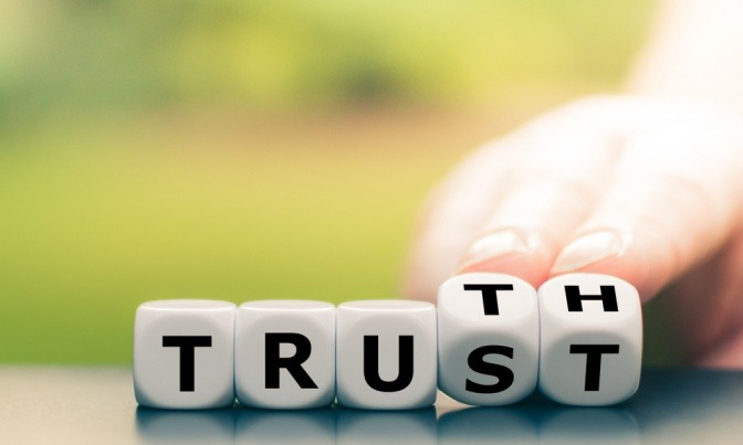 Mehrere Würfel bilden aneinandergereiht die Wörter trust und truth