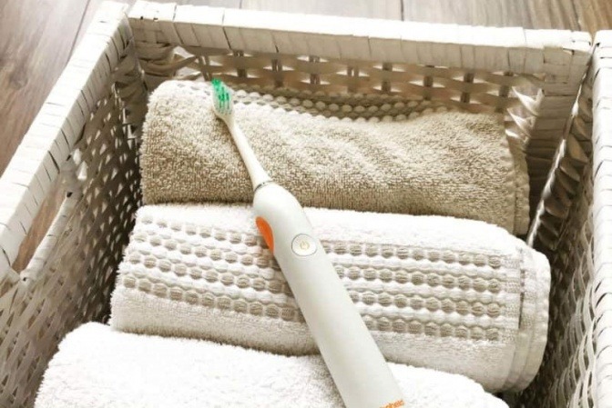 Eine elektrische Zahnbürste liegt in einem Wäschekorb zum Reinigen