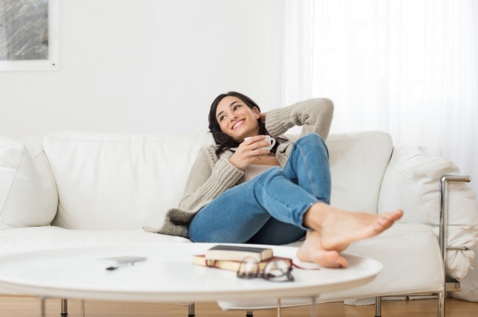 Frau entspannt am Sofa