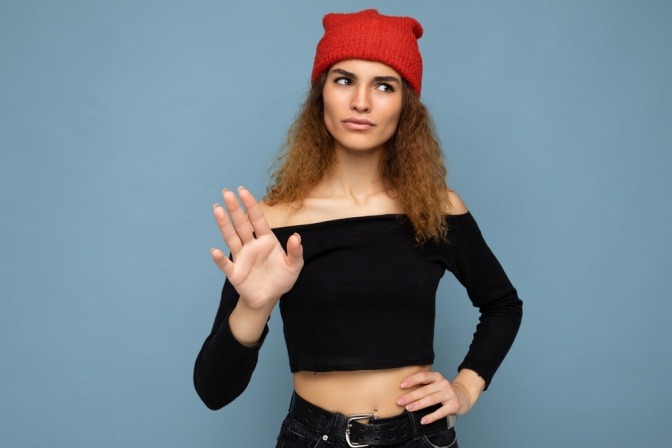 Selbstbewusste junge Frau macht Stop-Geste.