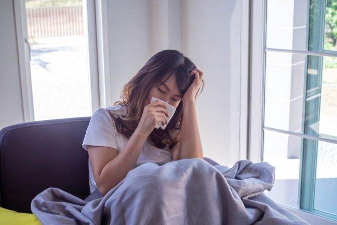Eine Frau hat Erkältung oder Grippe mit Anzeichen Schnupfen