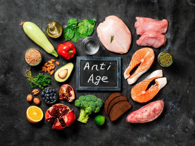 Lebensmittel wie Fleisch, Fisch, Gemüse und Nüsse, dazu ein Schild mit der Aufschrift "Anti Age"