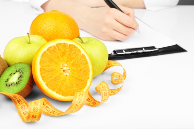 Ein Ernährungsplan wird geschrieben, im Vordergrund Obst