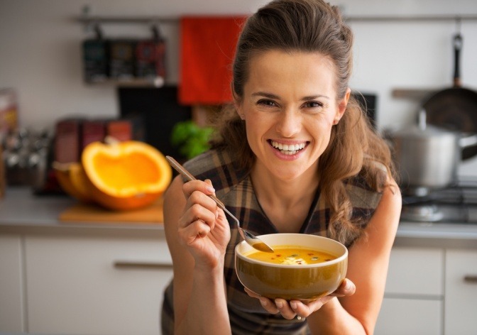 Frau isst Kürbiscremesuppe für Haarwachstum