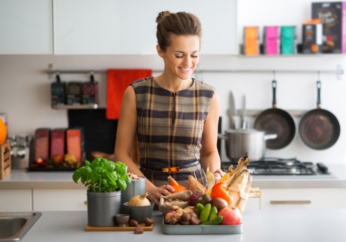 Frau mit frischem Gemüse in der Küche