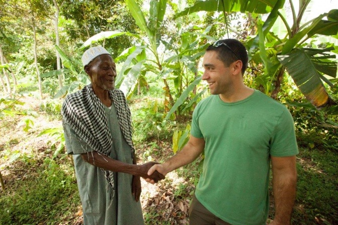 Ein Mitarbeiter von FAIRTRADE schüttelt einem FAIRTRADE-Produzenten die Hand