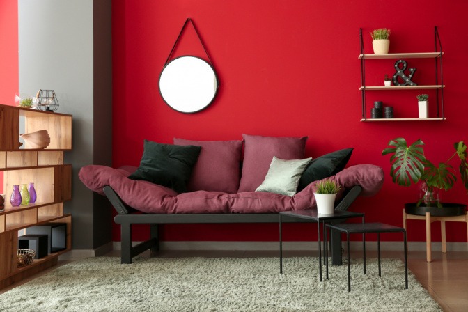 Modernes Interieur mit roter Wandfarbe und Sofa