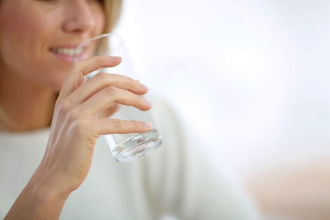 Eine Frau fastet und trinkt Wasser