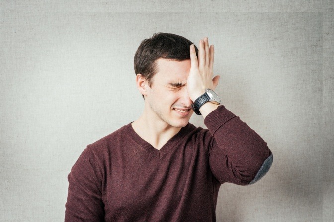 Ein junger Mann klatscht nach einem Fehler die Hand vor die Stirn.