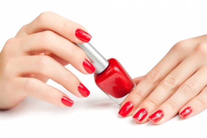 zwei Hände sind groß abgebildet. Sie haben rote Fingernägel und die Finger berühren den roten Nagellack in der Mitte des Bildes