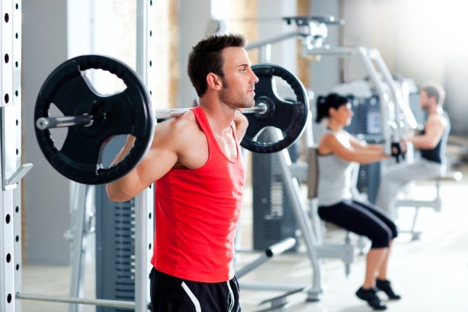 Ein Mann im Fitnessstudio fragt sich wie lange muss ich trainieren um Muskeln aufzubauen