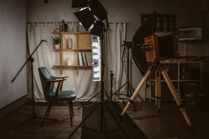 In einem Fotostudio stehen ein Stuhl und eine große Kamera