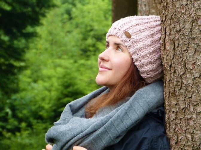 Eine Frau lehnt an einem Baum