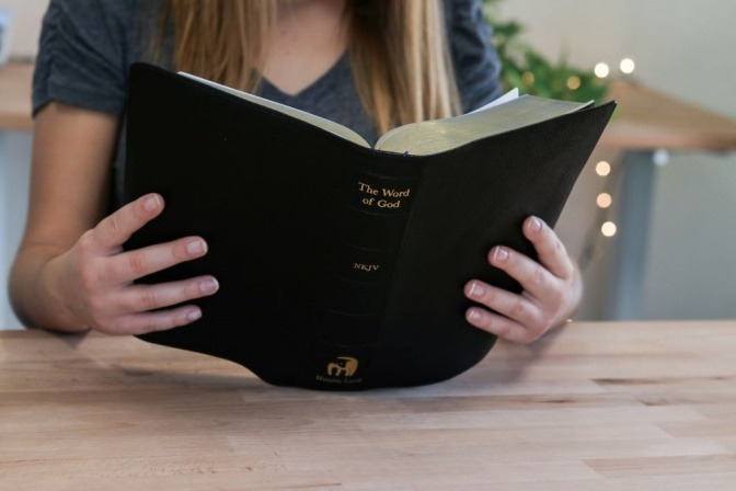 Eine Frau liest in einem Buch über Gott