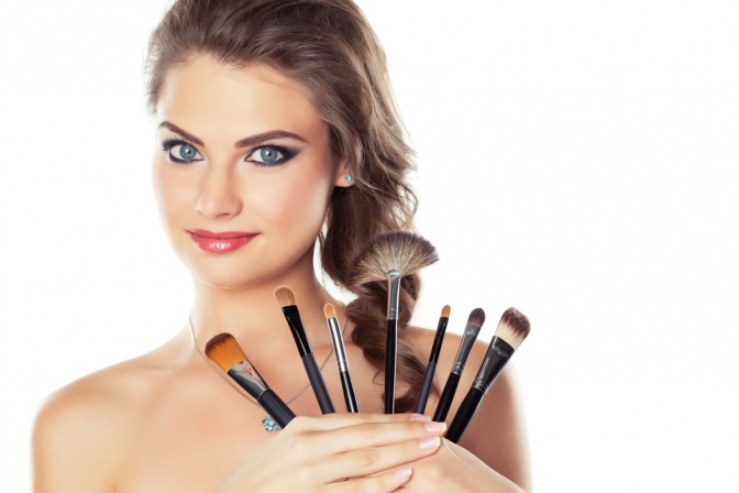 Eine Frau mit verschiedenen Make up Pinseln
