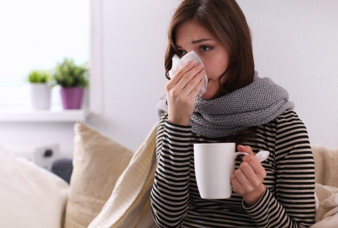 Frau mit Taschentuch stärkt schwaches Immunsystem mit Tee