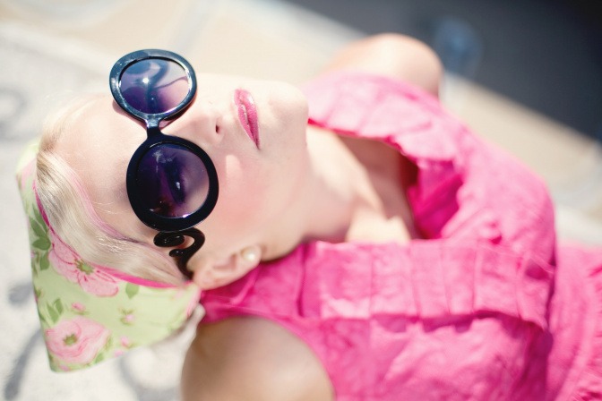Eine Frau mit Sonnenbrille schaut nach oben