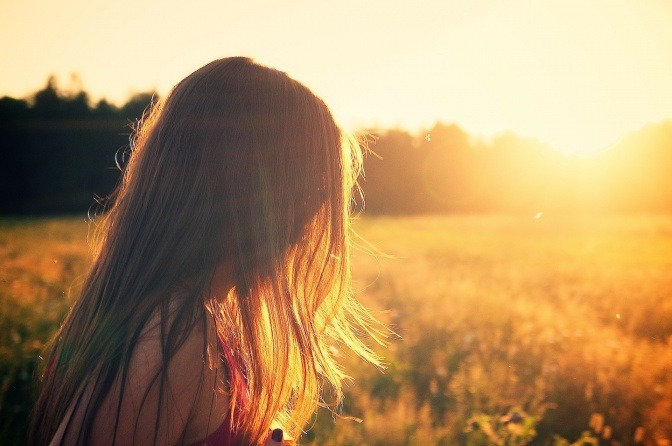 Eine Frau steht auf einem Feld im Sonnenschein