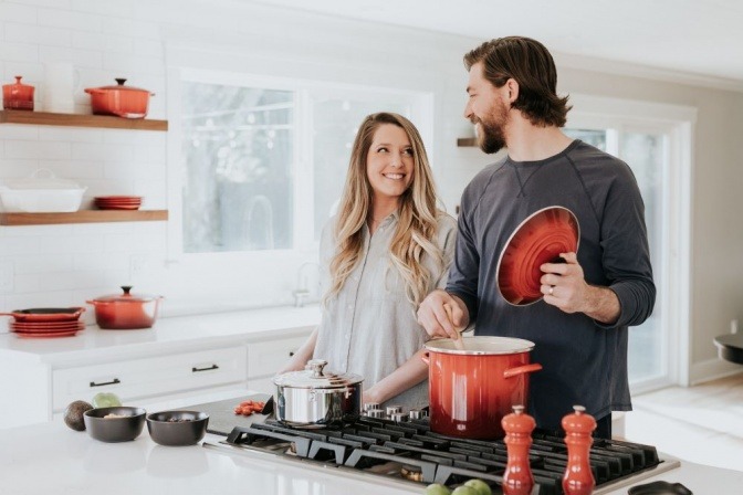 Eine Frau und ein Mann kochen miteinander und sehen glücklich aus