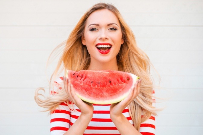 Eine Frau hält eine Wassermelone als Frucht zum Abnehmen