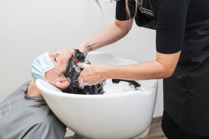 Gefärbte Haare waschen im Salon mit Shampoo