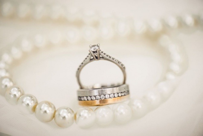 Schmuck (Kette, Ring aus Gold und Silber) liegt auf einer Fläche