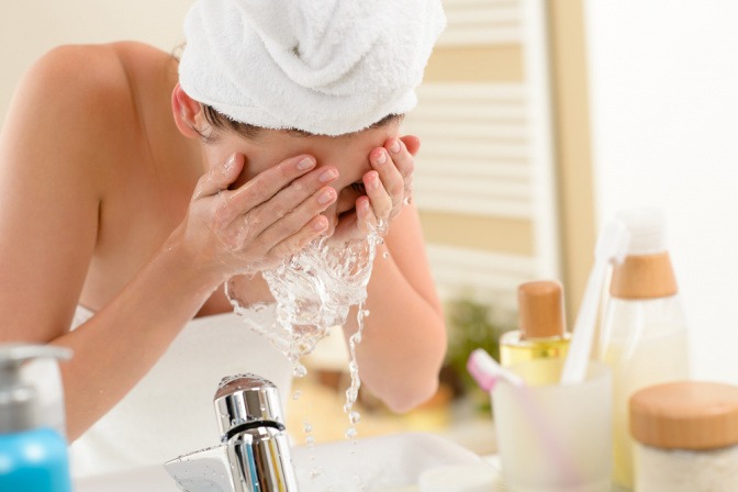 Eine Frau wäscht ihr Gesicht